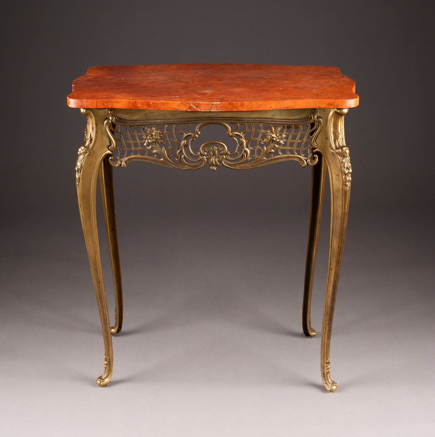 An intricately cast bronze sidetable with 'Rosso Verona' marble and ornate rocaille lattice work, French (?) 1800s