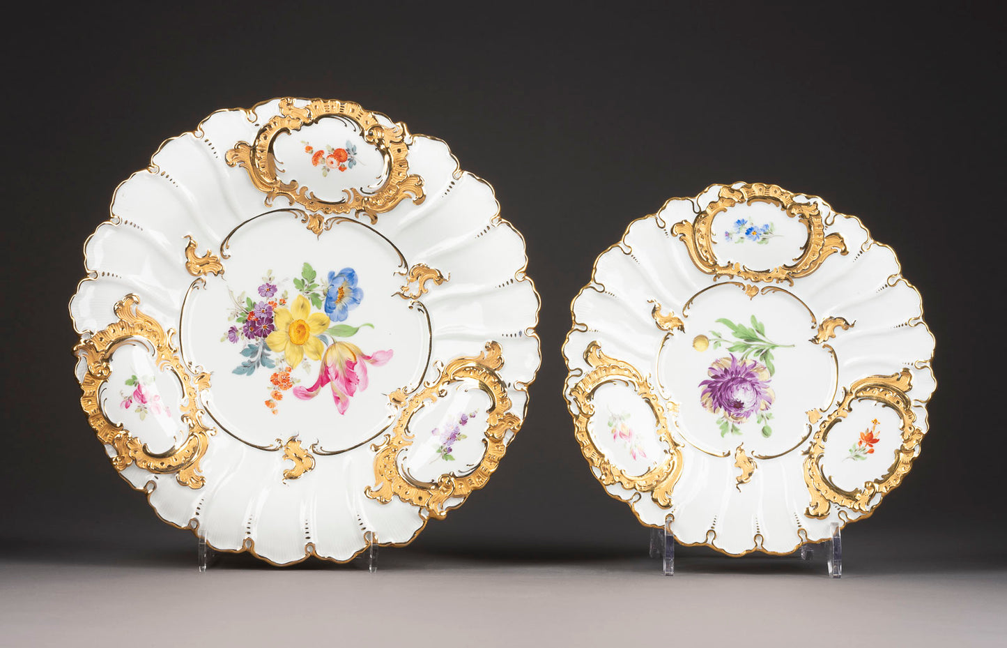 A striking pair of beautifully molded, hand painted and extensively gilt Meissen porcelain plates