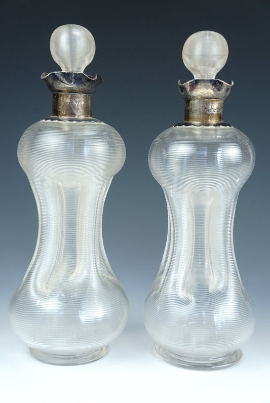 A pair of late Victorian silver-collared kutrolf decanters, each finely ribbed and having conforming hollow-blown stoppers by Saunders, Shepherd & Co Ltd, 1893